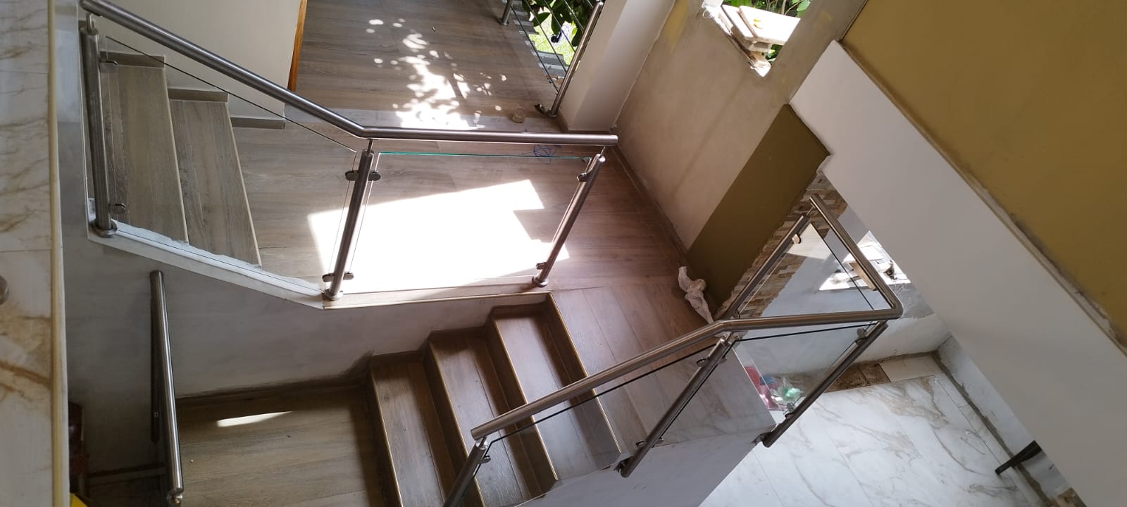 Escalera con barandal vidrio y madera